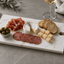 Luxe tapasplank van composiet met kaas, vleeswaren en olijven op gedekte tafel