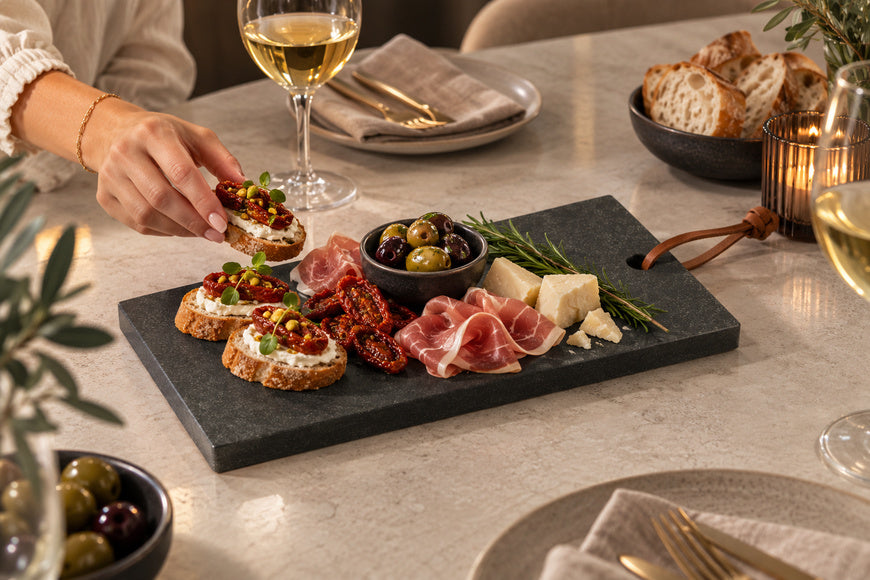 Neroli Signature tapasplank met hapjes op een gedekte eettafel