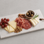 Luxe natuurstenen tapasplank met kazen, charcuterie, druiven en noten voor een stijlvolle borrel