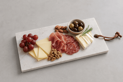 Luxe natuurstenen tapasplank met kazen, charcuterie, druiven en noten voor een stijlvolle borrel