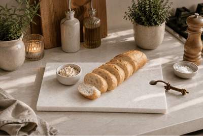 Natuurstenen tapasplank met vers stokbrood en kruidenboter op een stijlvolle keukenwerkplek