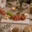 Lichte natuursteen tapasplank tijdens een gezellige borrel aan tafel met wijn en luxe hapjes