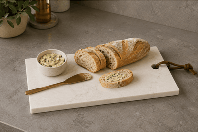 Natuurstenen tapasplank op keukenblad met stokbrood en kruidenboter