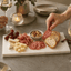 Moderne serveerplank van natuursteen op luxe eettafel met tapas