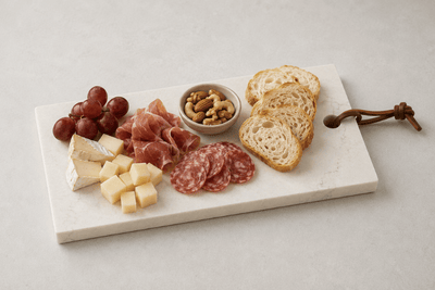 Witte borrelplank van composiet met kaas, charcuterie en stokbrood