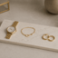 Sieraden plateau van composiet met gouden sieraden en horloge
