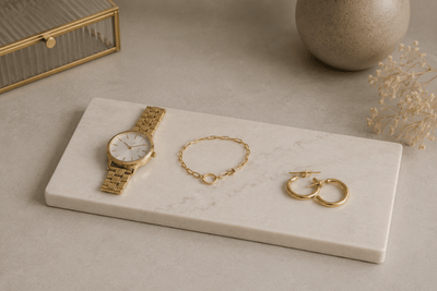 Sieraden plateau van composiet met gouden sieraden en horloge