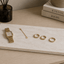 Sieradenplank van natuursteen met horloge en gouden sieraden