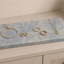 Azul Emerald Accessoireplank met gouden sieraden op een dressoir als luxe opbergplek voor horloge, ringen en armbanden.