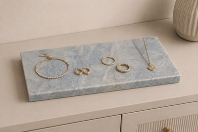 Azul Emerald Accessoireplank met gouden sieraden op een dressoir als luxe opbergplek voor horloge, ringen en armbanden.