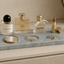 Azul Emerald Accessoireplank met luxe parfumflacons, make-up en sieraden als stijlvolle decoratie op een kaptafel of dressoir.