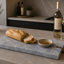 Azul Emerald Signature Tapasplank met vers brood, olijfolie en witte wijn op een modern keukeneiland.