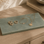 Rechthoekige Verde emerald natuurstenen plank met gouden sieraden, horloge, ringen en ketting.