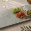 Verde emerald tapasplank gevuld met kazen, charcuterie, druiven, olijven en noten voor een stijlvolle borrelpresentatie.