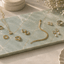 Rechthoekige Verde emerald natuurstenen plank met gouden sieraden, horloge, ringen en ketting.